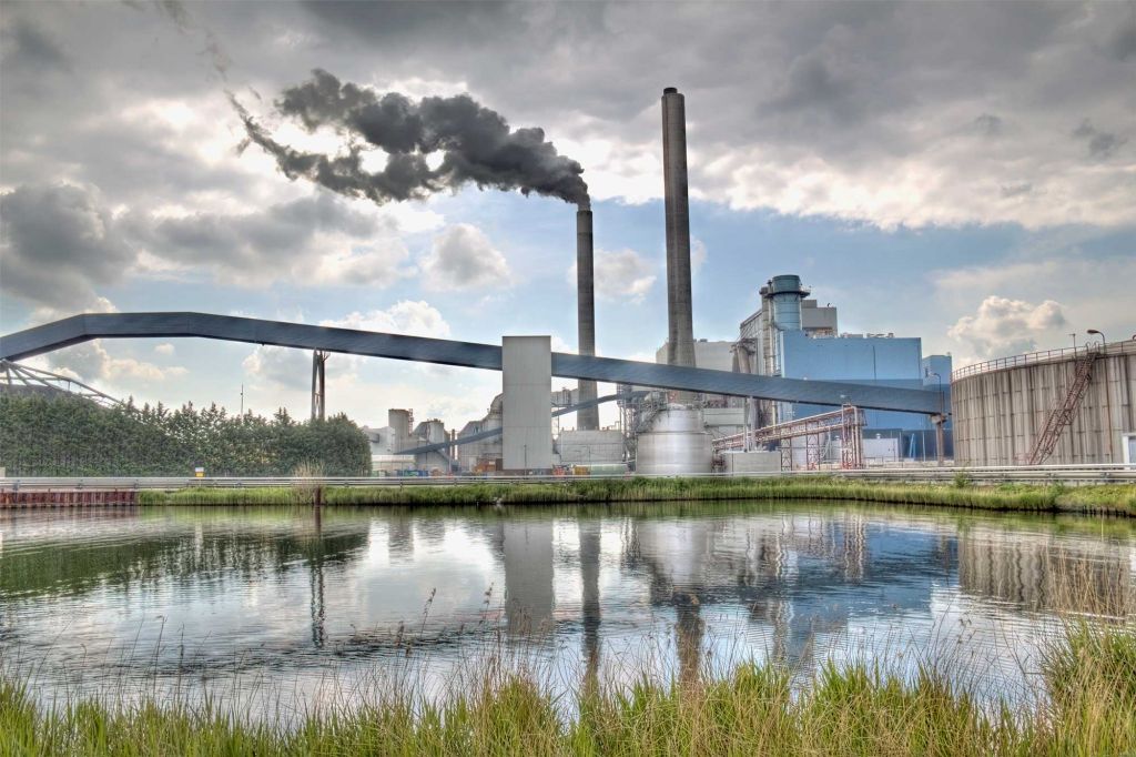 Factory with smokestacks and pond- Locus sustainability management software solutions