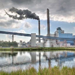Factory with smokestacks and pond- Locus sustainability management software solutions
