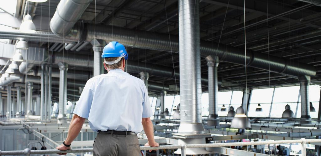 Manager in hardhat looking over his factory-Locus automation and sensors solutions prepare your organization for the Internet of Things